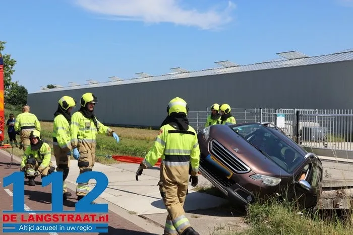 Auto neemt bocht te krap en belandt met zijkant in sloot in Vlijmen 3 Auto neemt bocht te krap en belandt met zijkant in sloot in Vlijmen 112 De Langstraat