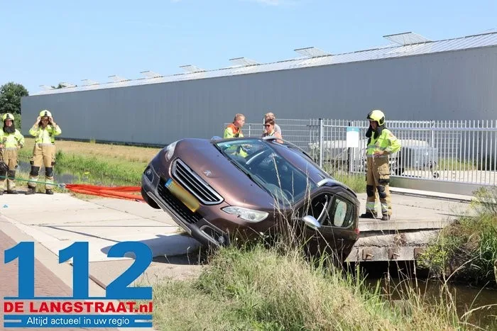 Auto neemt bocht te krap en belandt met zijkant in sloot in Vlijmen 15 Auto neemt bocht te krap en belandt met zijkant in sloot in Vlijmen 112 De Langstraat