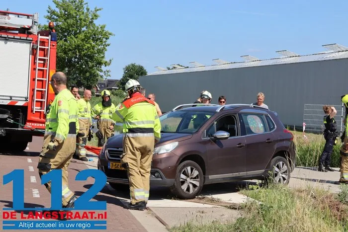 Auto neemt bocht te krap en belandt met zijkant in sloot in Vlijmen 21 Auto neemt bocht te krap en belandt met zijkant in sloot in Vlijmen 112 De Langstraat