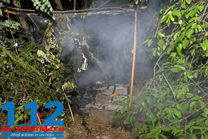 Brandweer blust achtergelaten slaapplek in bossen bij Waalwijk met emmers water 112 De Langstraat