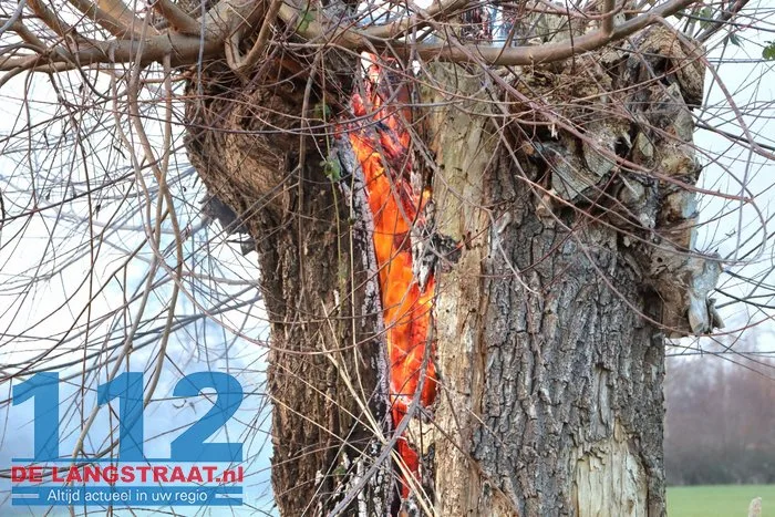Jongentje in brandweerkleding helpt brandweer bij blussen brandende knotwilg Sprang-Capelle 112 De Langstraat