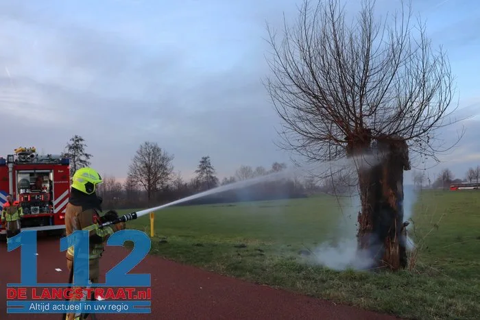 Jongentje in brandweerkleding helpt brandweer bij blussen brandende knotwilg Sprang-Capelle 112 De Langstraat