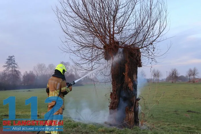 Jongentje in brandweerkleding helpt brandweer bij blussen brandende knotwilg Sprang-Capelle 112 De Langstraat