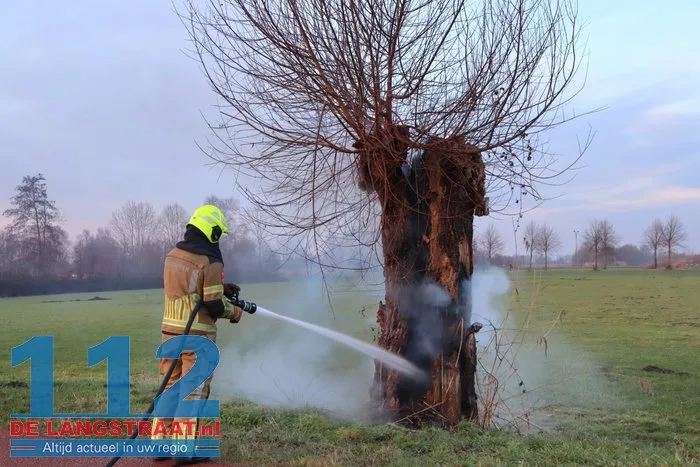 Jongentje in brandweerkleding helpt brandweer bij blussen brandende knotwilg Sprang-Capelle 112 De Langstraat
