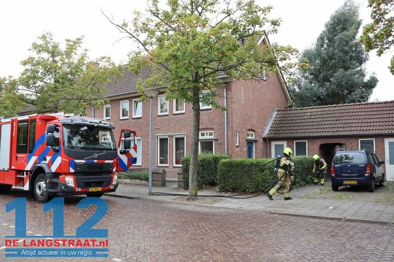 Brandweer blust brandende coniferen na stoken in tuin Waalwijk 112 De Langstraat