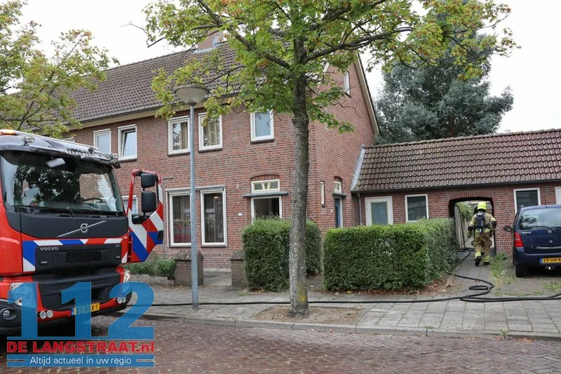 Brandweer blust brandende coniferen na stoken in tuin Waalwijk 112 De Langstraat