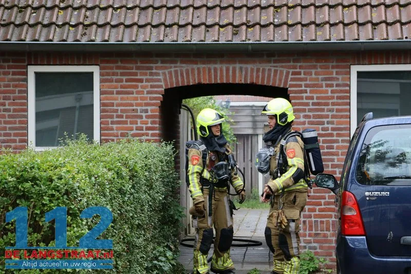 Brandweer blust brandende coniferen na stoken in tuin Waalwijk 112 De Langstraat