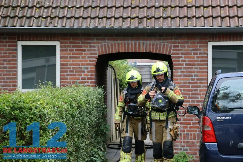 Brandweer blust brandende coniferen na stoken in tuin Waalwijk 112 De Langstraat