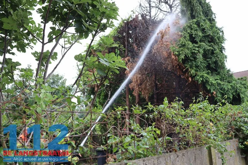 Brandweer blust brandende coniferen na stoken in tuin Waalwijk 112 De Langstraat