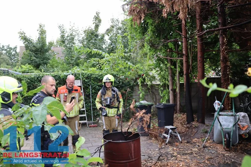 Brandweer blust brandende coniferen na stoken in tuin Waalwijk 112 De Langstraat