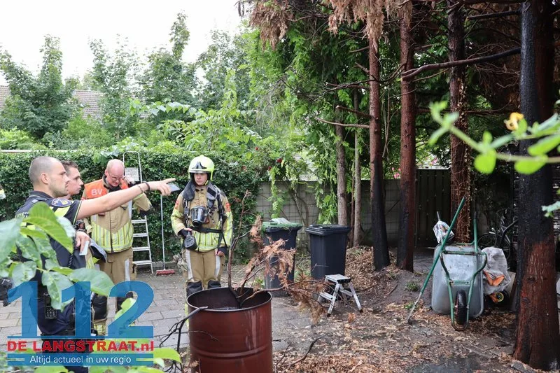 Brandweer blust brandende coniferen na stoken in tuin Waalwijk 112 De Langstraat