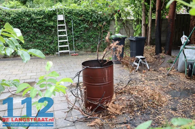 Brandweer blust brandende coniferen na stoken in tuin Waalwijk 112 De Langstraat